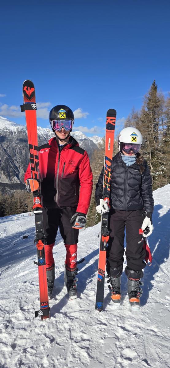 Two Ski Race Academy Mals athletes holding skis in the mountains